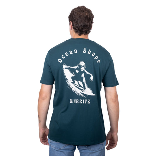 Tee-shirt unisexe vert foncé en coton biologique avec gros dessin de singe qui surfe et écriture « ocean shape Biarritz » beige dans le dos, vu de dos sur mannequin homme 