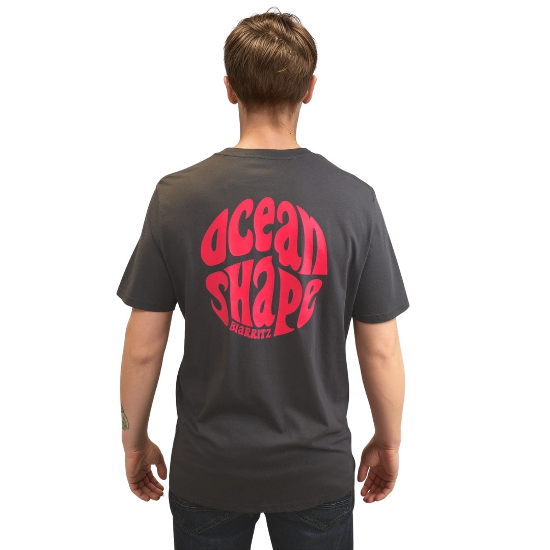 Tee-shirt gris foncé en coton biologique avec grand logo bubble ocean shape Biarritz rose fluo en haut du dos, vu de dos sur mannequin homme.