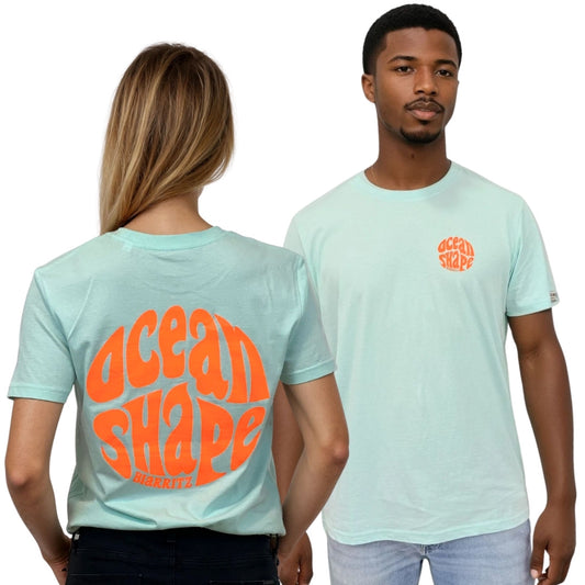 Tee-shirt unisexe en coton biologique bleu caraïbe.
Devant : petit logo bubble "Ocean Shape Biarritz" orange fluo sur la poitrine gauche.
Dos : gros logo bubble "Ocean Shape Biarritz" orange fluo.
Vue de dos sur mannequin femme et de face sur mannequin homme.