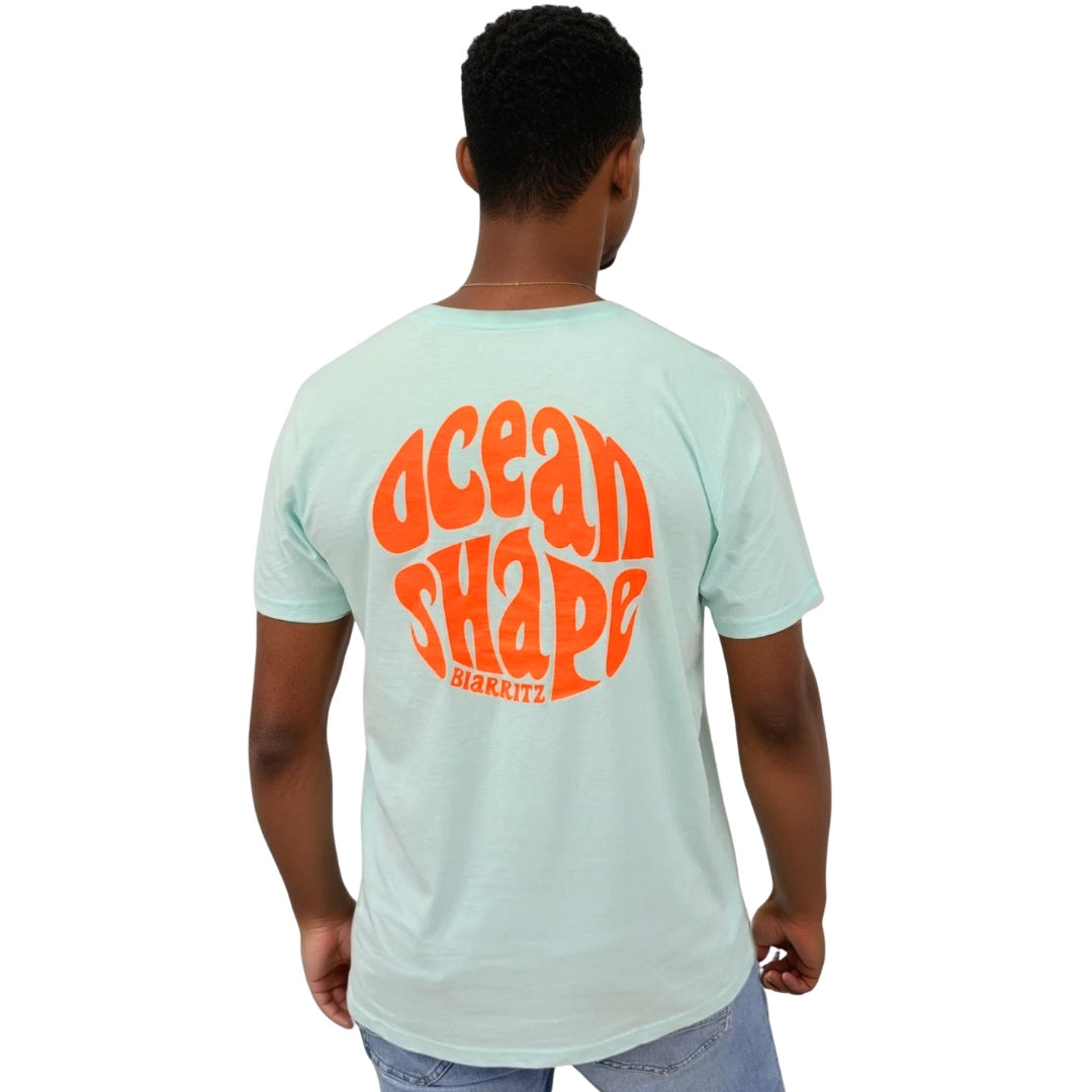 Tee-shirt unisexe en coton biologique bleu caraïbe.
Gros logo bubble "Ocean Shape Biarritz" orange fluo.
Vue de dos sur mannequin homme.