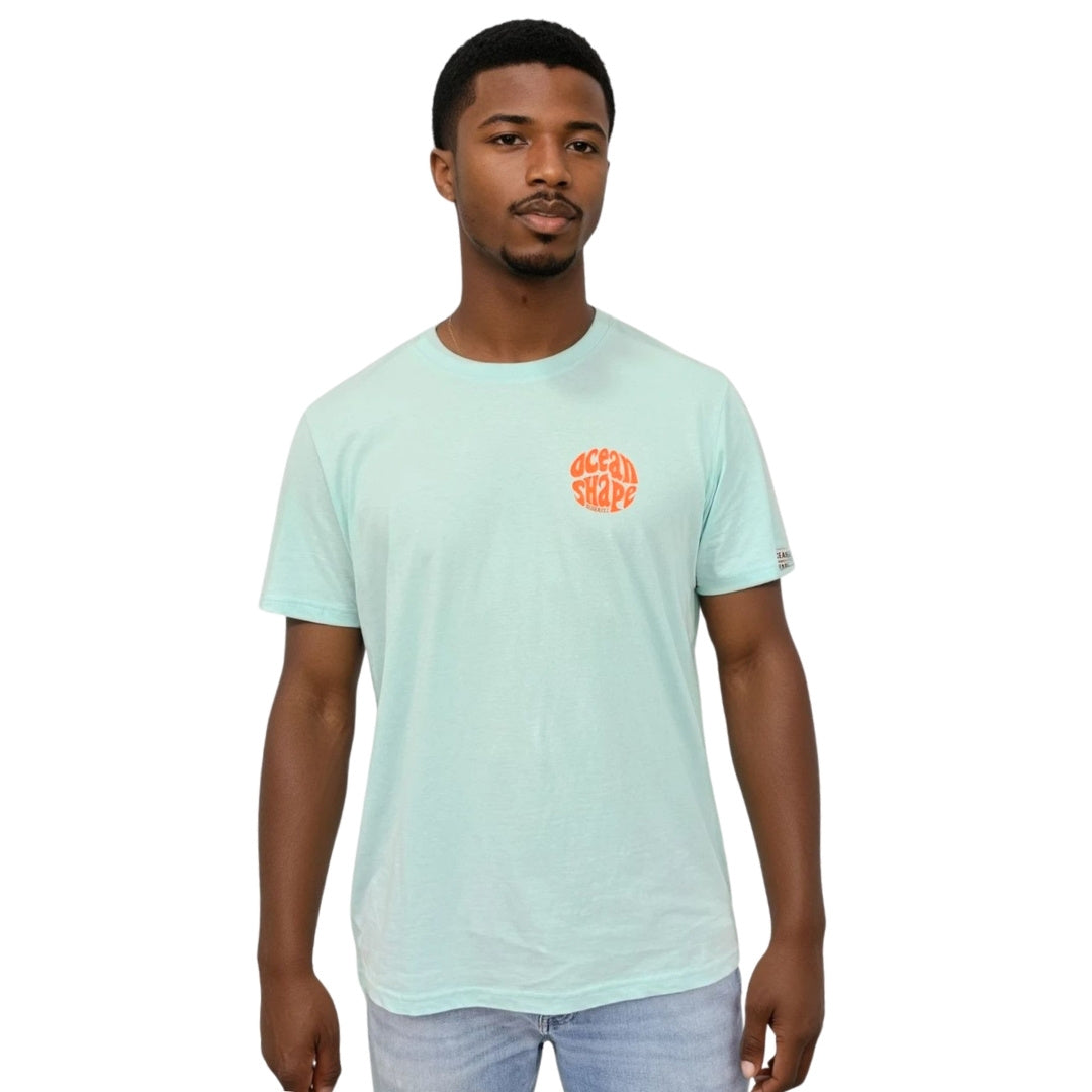 Tee-shirt unisexe en coton biologique bleu caraïbe, petit logo bubble "Ocean Shape Biarritz" orange fluo sur la poitrine gauche.
Vue de face sur mannequin homme.