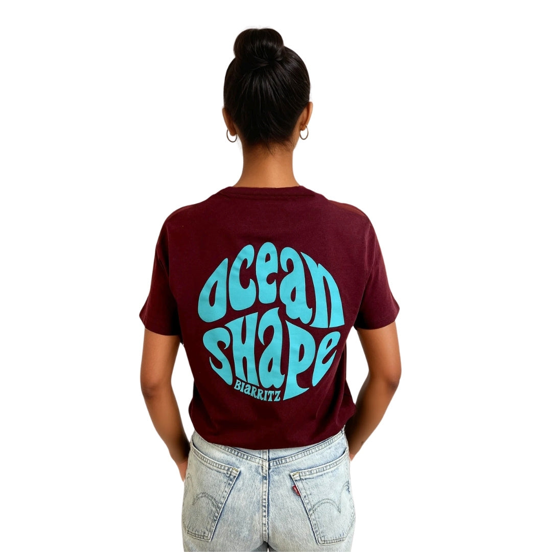 tee-shirt unisexe en coton biologique bordeaux foncé
dos : gros logo bubble "ocean shape biarritz" bleur turquoise
vu de dos sur mannequin femme
