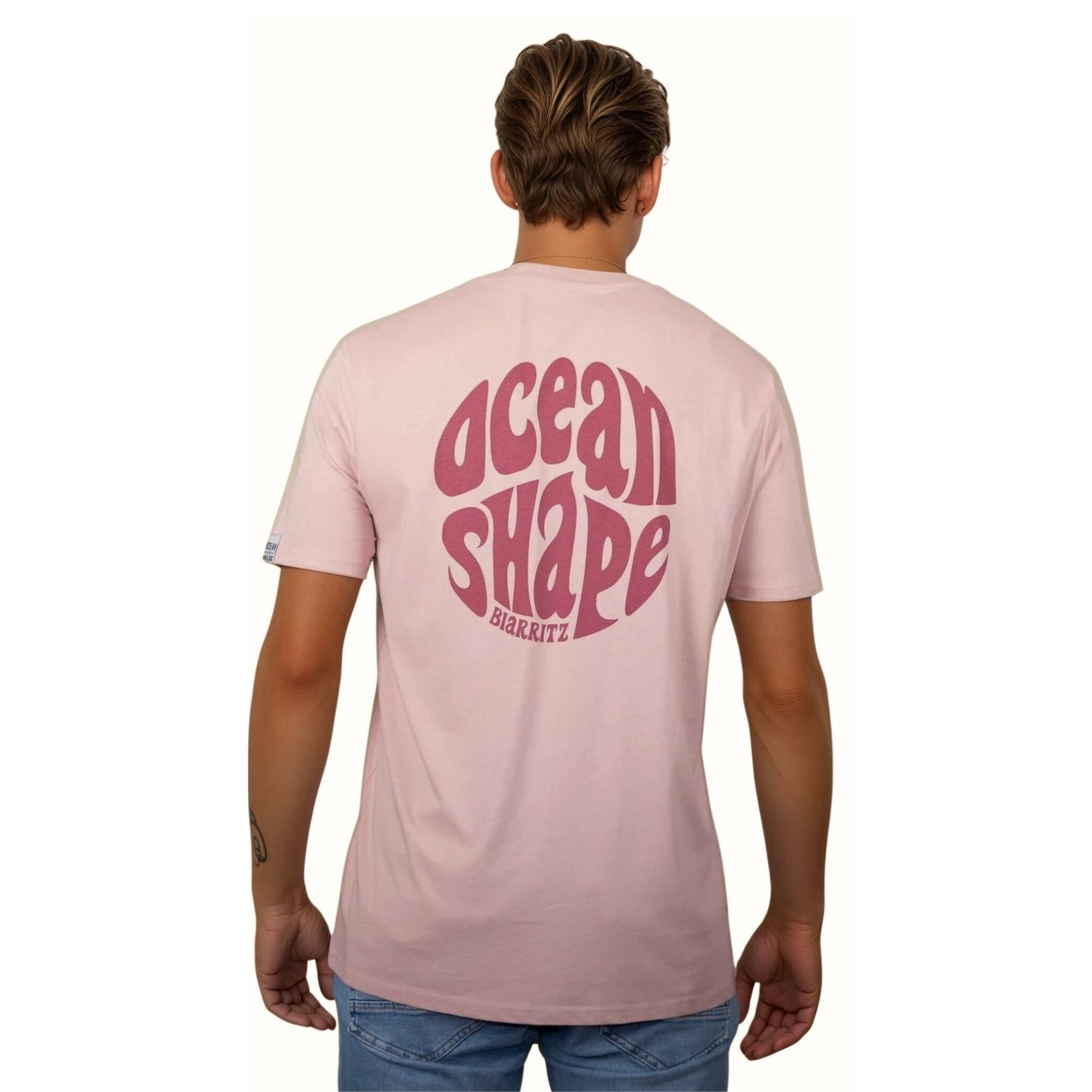 Tee-shirt unisexe rose pale en coton biologique avec gros logo ocean shape Biarritz bubble rose foncé en haut du dos, vu de dos sur mannequin homme