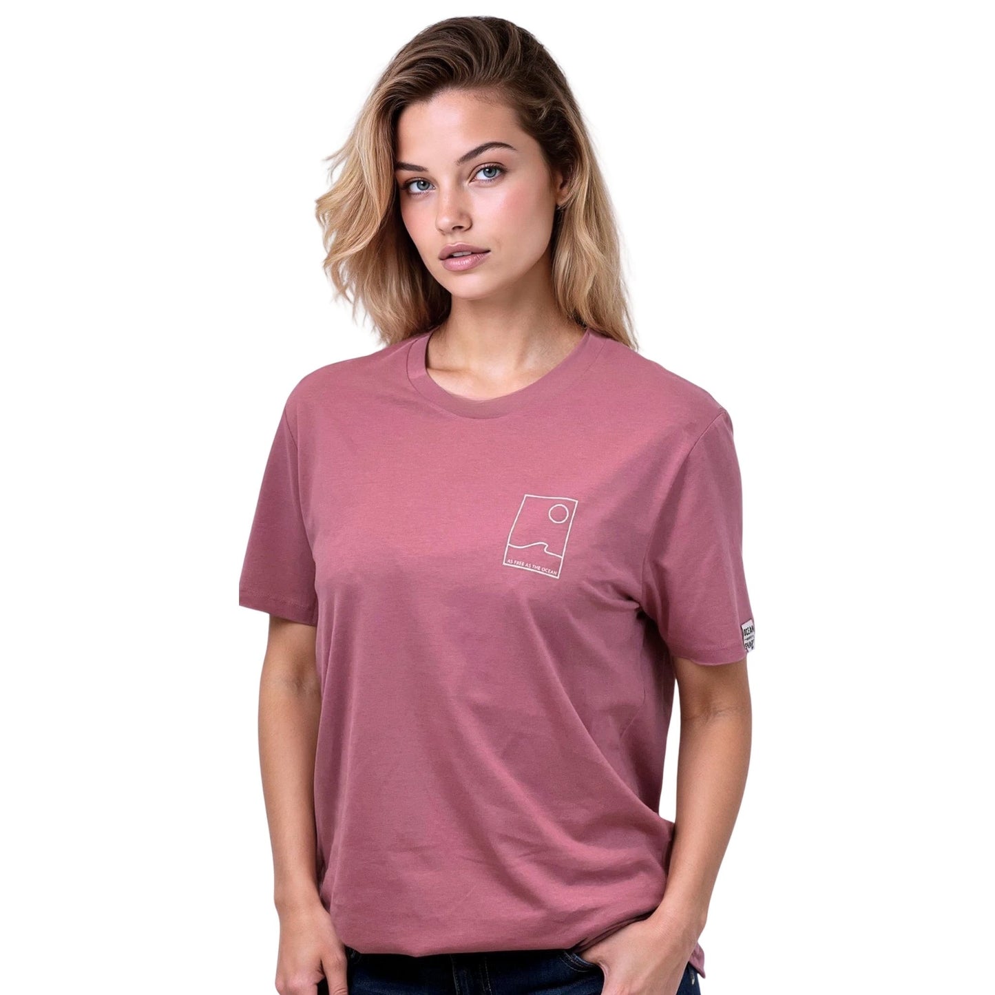 Tee-shirt unisexe rose foncé en coton biologique avec petit encadré vague / soleil minimaliste et écriture "free as ocean" beige sur la poitrine gauche, vu de face sur mannequin femme.