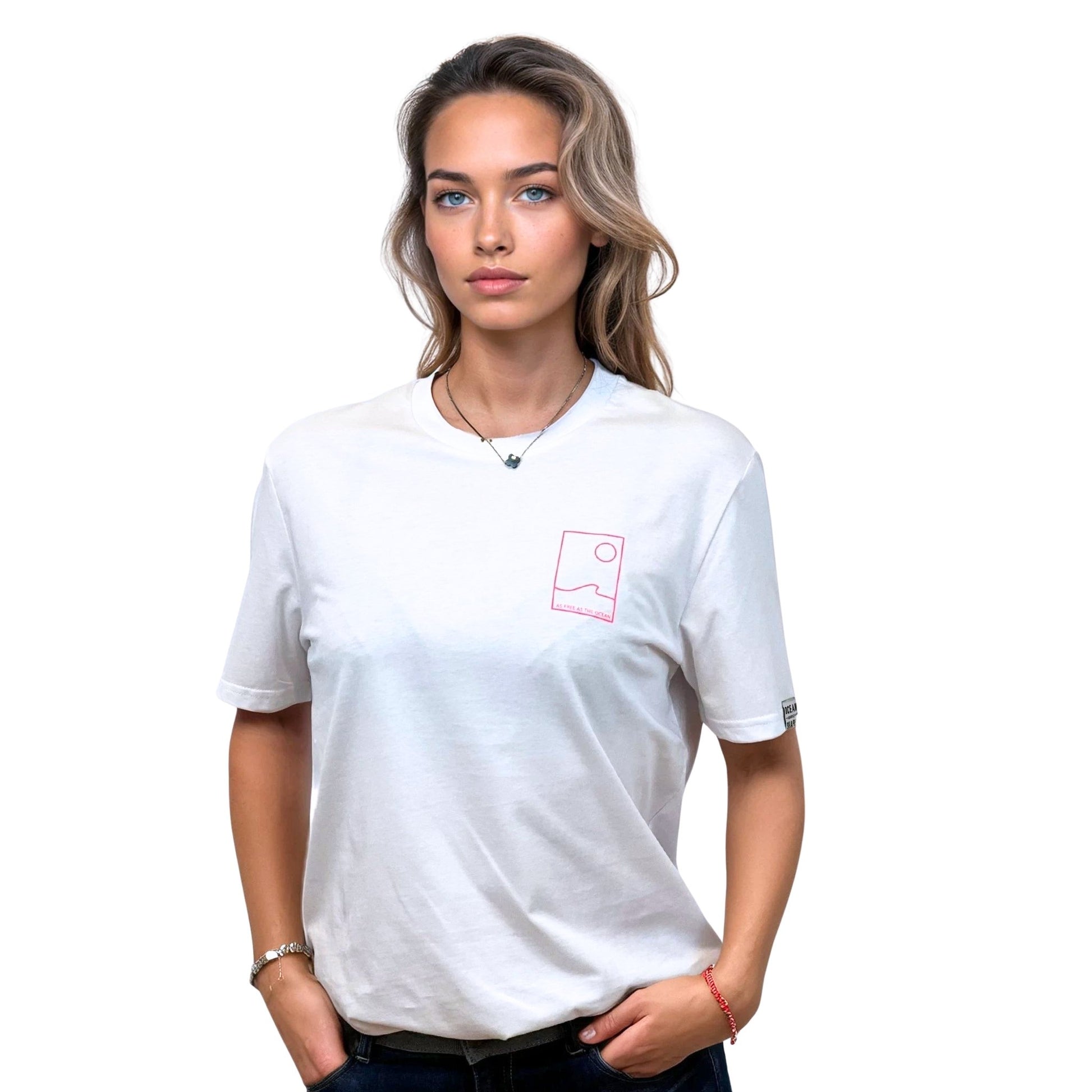 Tee-shirt unisexe blanc en coton biologique avec petit encadré vague / soleil minimaliste + écriture "free as ocean" rose fluo sur la poitrine, vu de face sur mannequin femme.