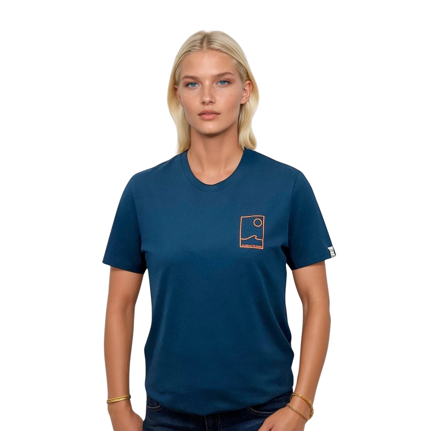 Tee-shirt unisexe bleu petrole en coton biologique avec petit encadré vague / soleil minimaliste + écriture "free as ocean" orange fluo sur la poitrine, vu de face sur mannequin femme.