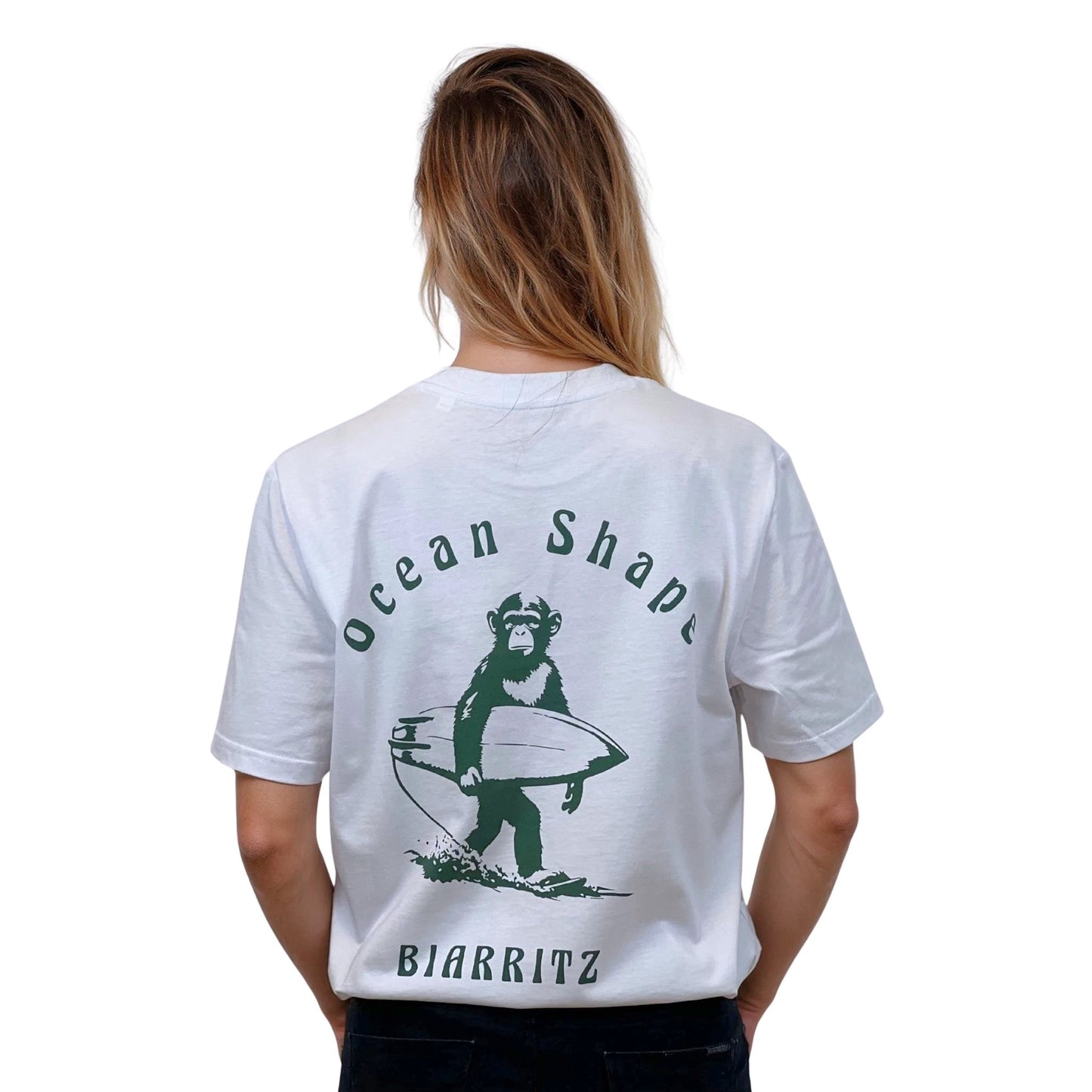 Tee-shirt unisexe blanc en coton biologique avec gros dessin de singe surfer + écriture "ocean shape Biarritz" vert dans le dos, vu de dos sur mannequin femme.