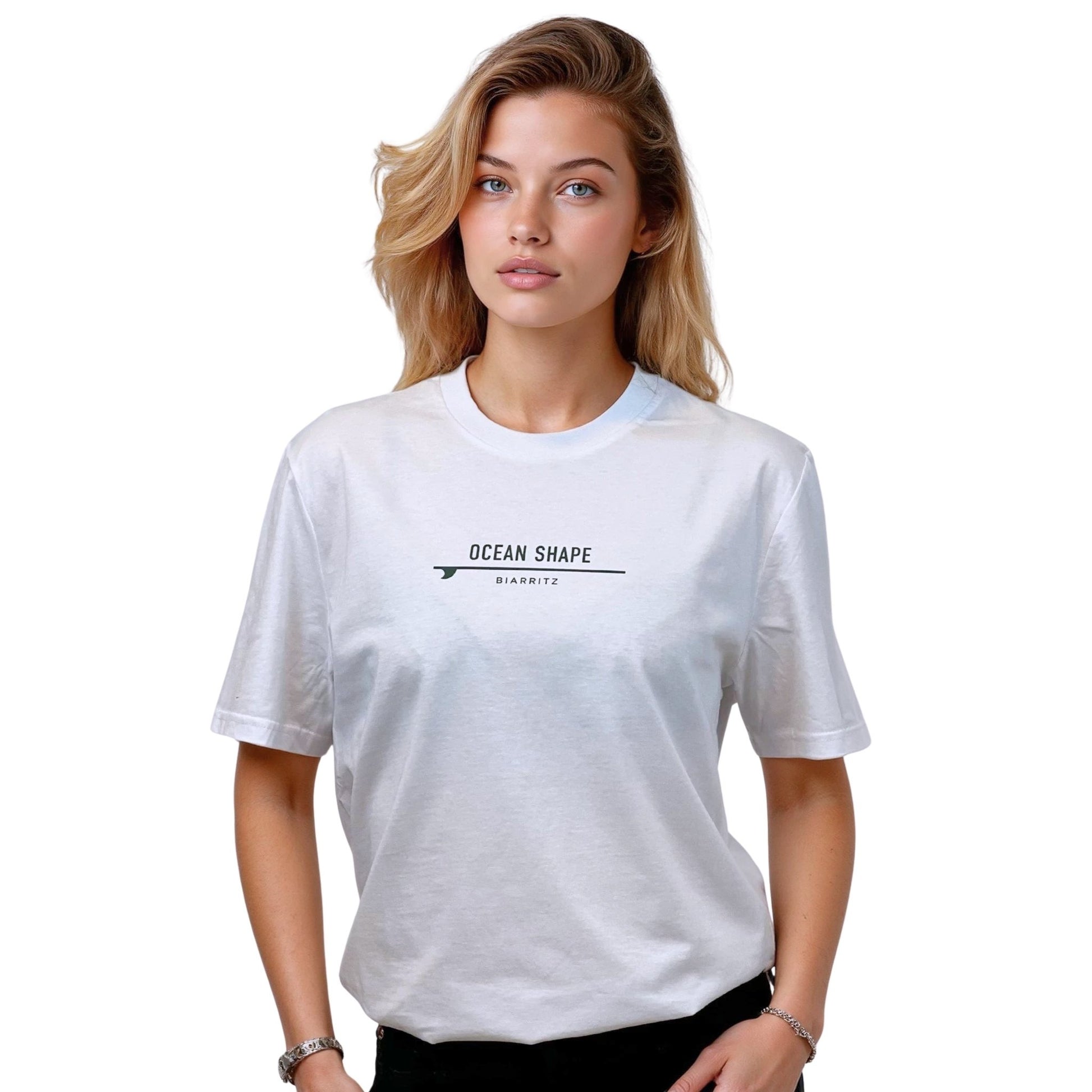 Tee-shirt unisexe blanc en coton biologique avec petite signature "ocean shape Biarritz" sur surf vert sur la poitrine, vu de face sur mannequin femme.