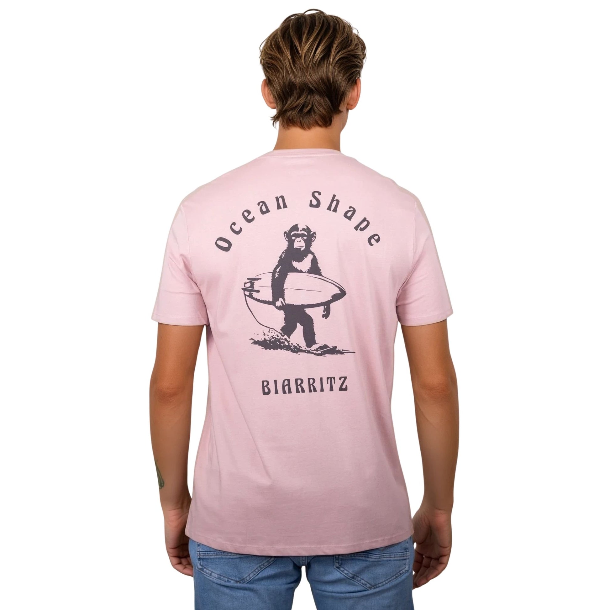 Tee-shirt unisexe rose pale en coton biologique avec gros dessin de singe surfeur et écriture « ocean shape Biarritz » marron foncé dans le dos, vu de dos sur mannequin homme 