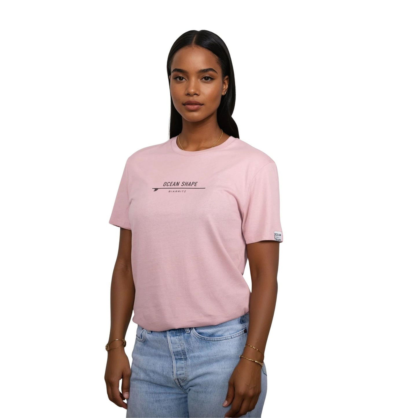 Tee-shirt unisexe rose pale en coton biologique avec petite signature "ocean shape Biarritz" sur surf marron foncé sur la poitrine, vu de face sur mannequin femme
