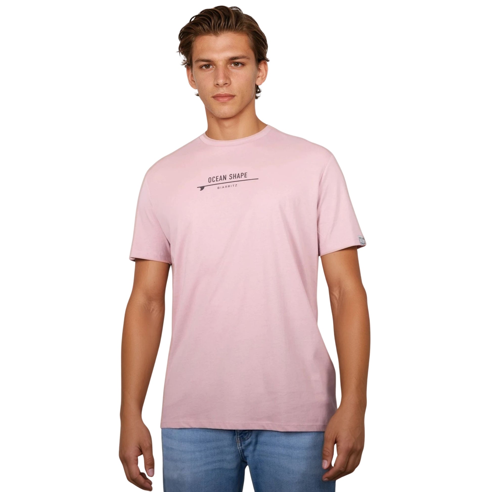 Tee-shirt unisexe rose pale en coton biologique avec petite signature "ocean shape Biarritz" sur surf marron foncé sur la poitrine, vu de face sur mannequin homme