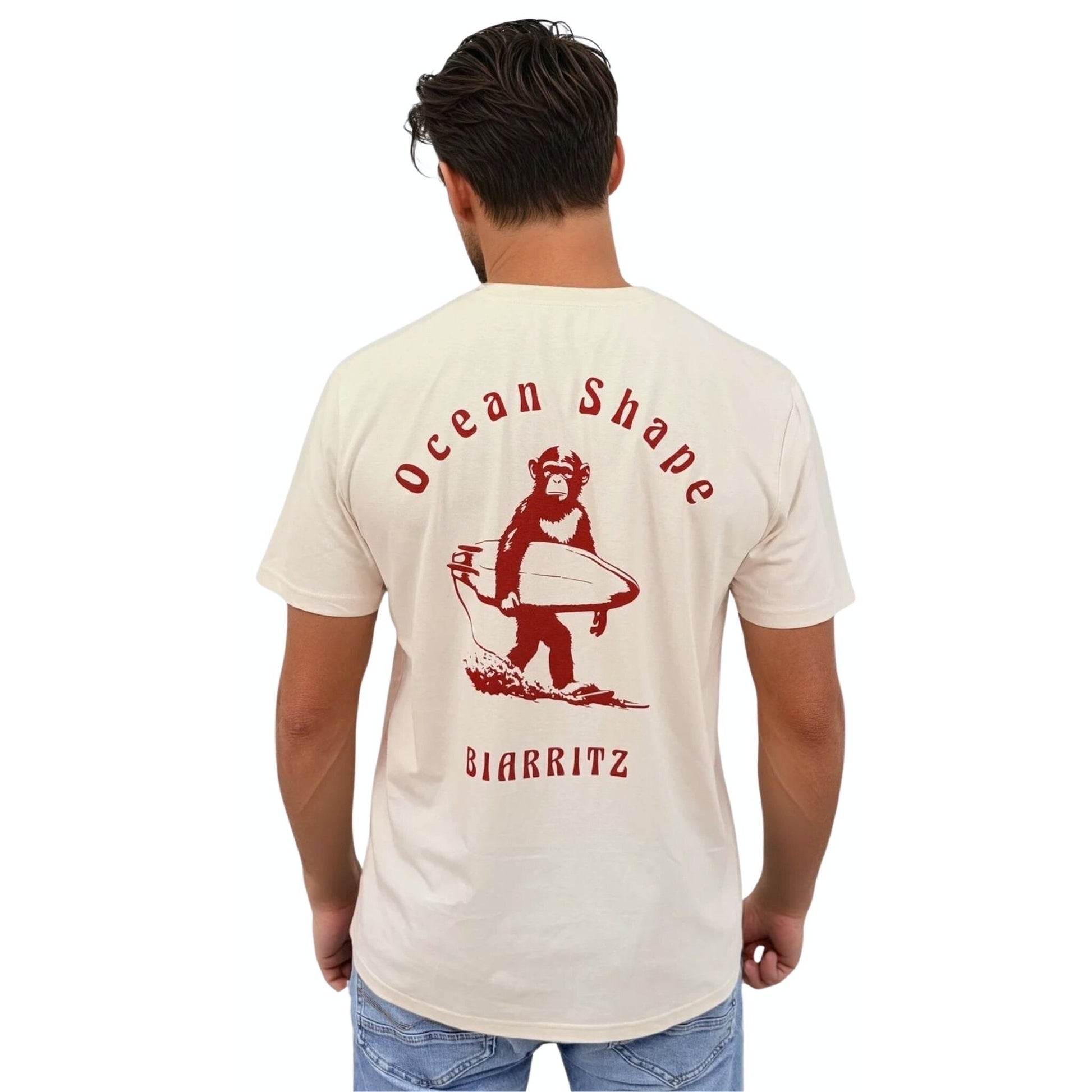 Tee-shirt unisexe écru en coton biologique, grand dessin de singe qui tient une planche de surf + écriture "Ocean Shape Biarritz" dans le dos.
Vu de dos sur mannequin femme.