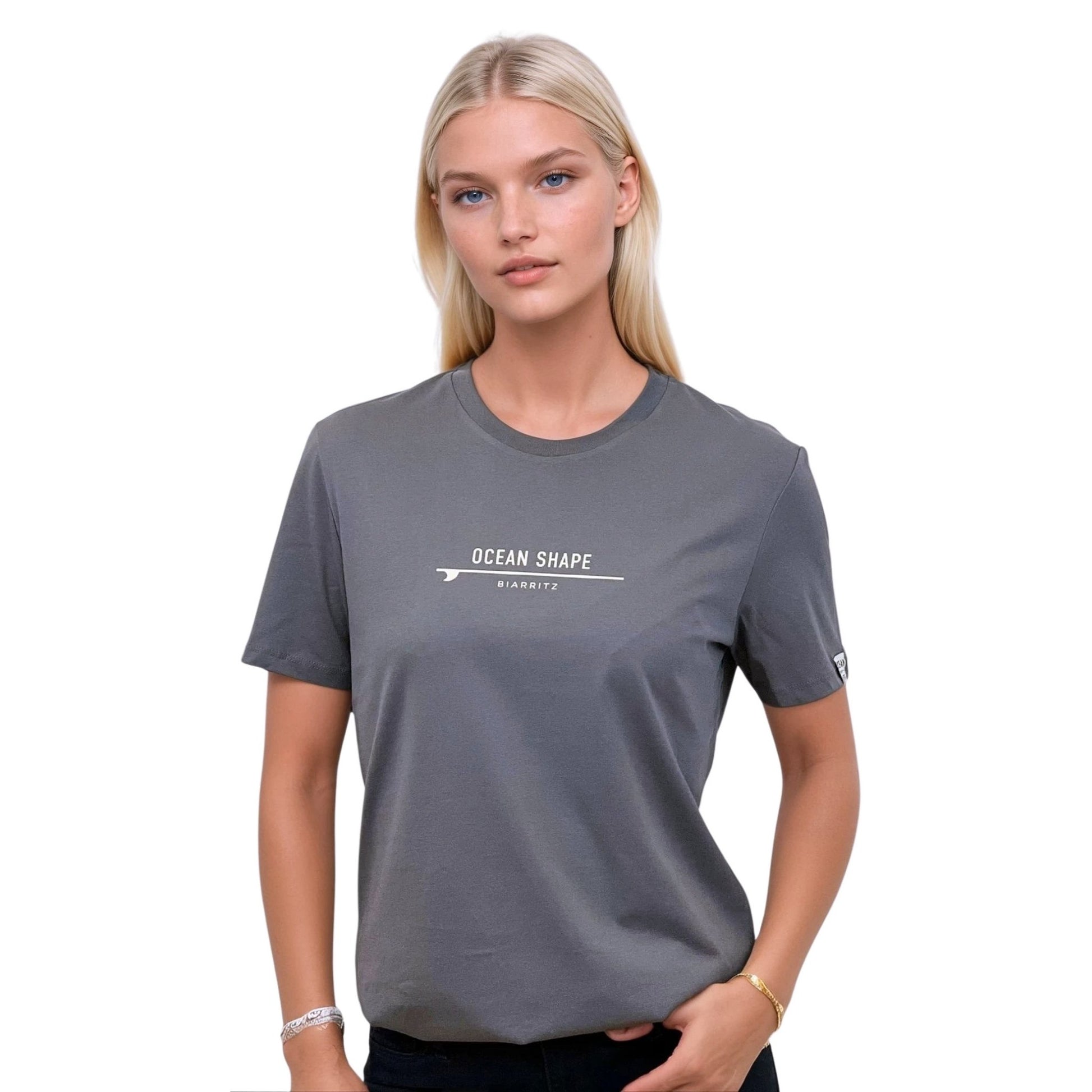 Tee-shirt unisexe gris foncé en coton biologique avec signature "ocean shape Biarritz" sur surf beige sur la poitrine, vu de face sur mannequin femme.