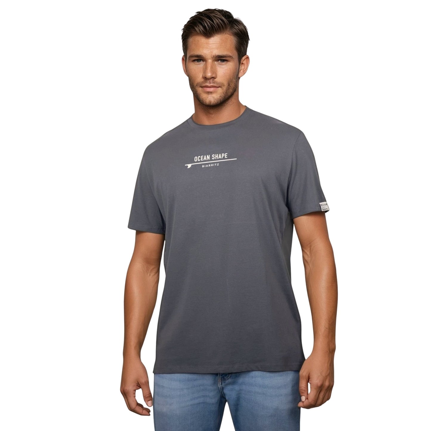 Tee-shirt unisexe gris foncé en coton biologique avec signature "ocean shape Biarritz" sur surf beige sur la poitrine, vu de face sur mannequin homme.
