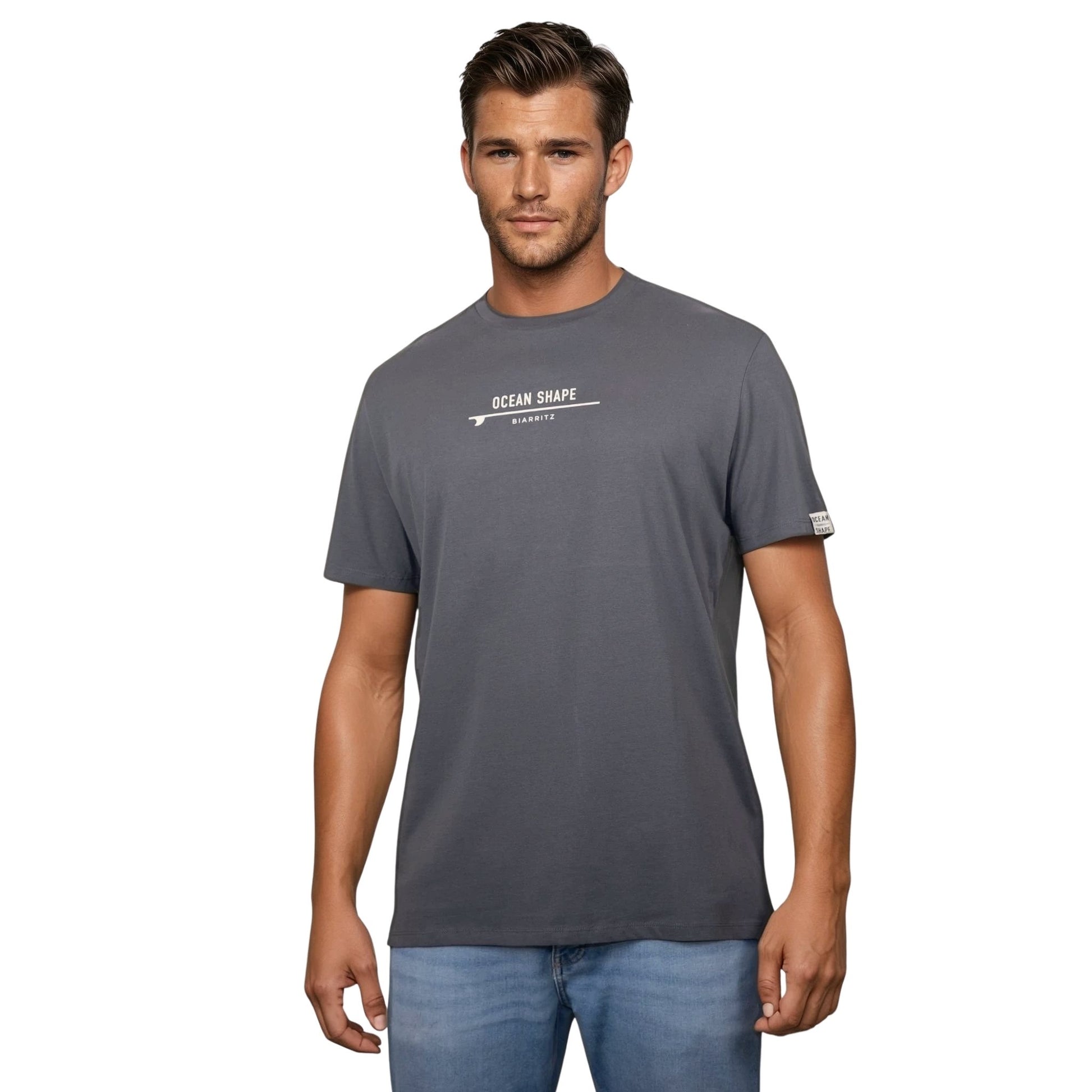 Tee-shirt unisexe gris foncé en coton biologique avec signature "ocean shape Biarritz" sur surf beige sur la poitrine, vu de face sur mannequin homme.