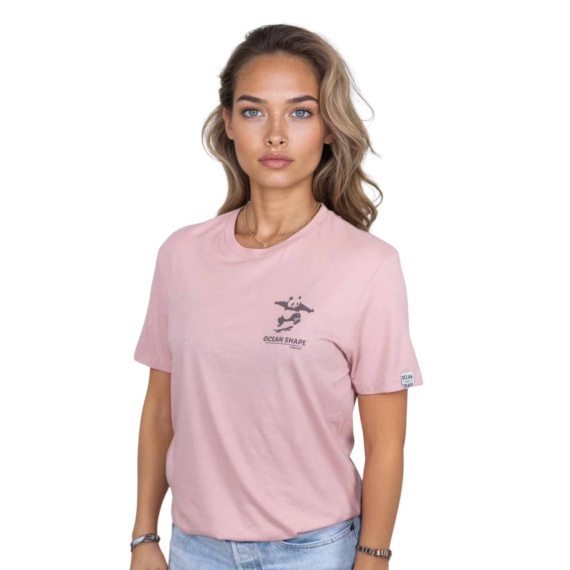 T-shirt unisexe rose pale en coton biologique avec petit dessin panda skateur marron foncé sur la poitrine, vue de face sur mannequin femme.