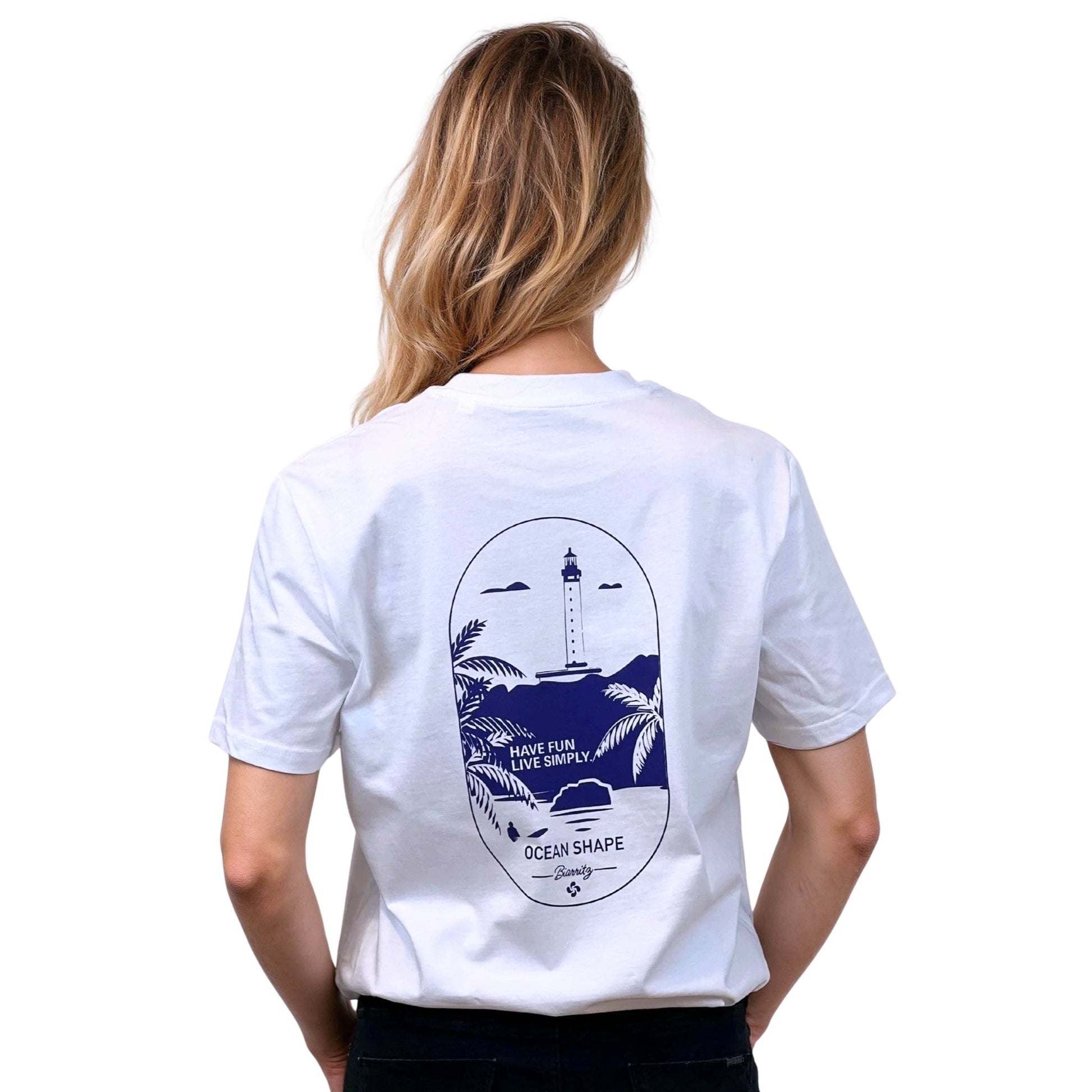 T-shirt unisexe blanc en coton biologique avec grand dessin phare de Biarritz bleu dans le dos, vu de dos sur mannequin femme.