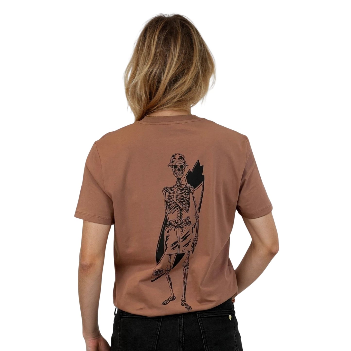 T-shirt unisexe sienna en coton biologique avec grand dessin noir de squelette surfeur dans le dos, vu de dos sur mannequin femme.